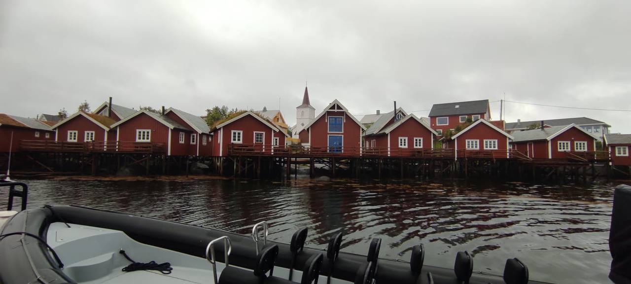 Blick auf Leknes auf den Lofoten – Häuser am Wasser mit Kirche