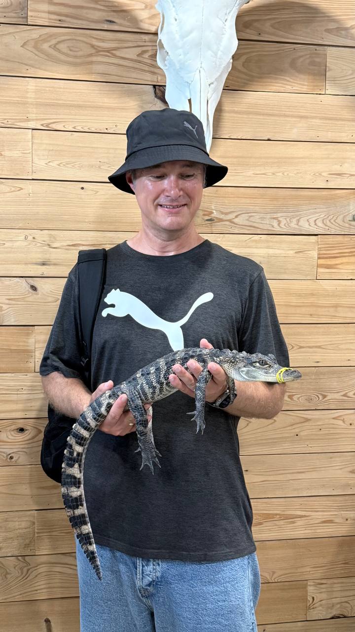 Marcel hält einen Baby-Alligator auf dem Arm im Jungle Doria Wildlife Park