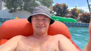 Pooltag in Florida – Entspannung auf dem orangefarbenen Schwimmring im Pool, dahinter ein grüner INTEX-Alligator