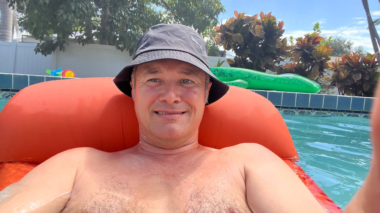 Pooltag in Florida – Entspannung auf dem orangefarbenen Schwimmring im Pool, dahinter ein grüner INTEX-Alligator