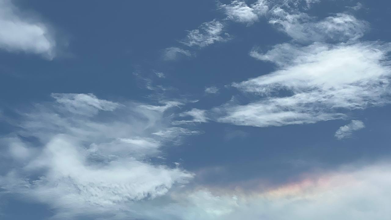 Blauer Himmel mit Wolkenformationen und Regenbogen-Effekt über dem Robinson Preserve Park